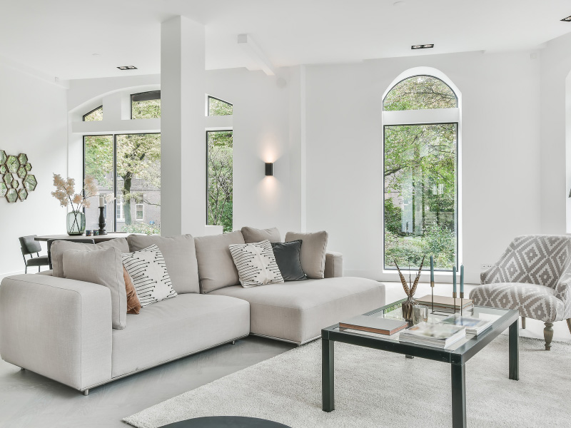 clean-staged-living-and-connected-dining-room-with-large-arched-glass-windows