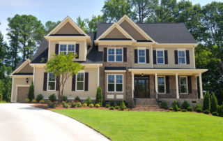 two-story-home-with-beige-siding-vibrant-green-lawn-and-long-driveway