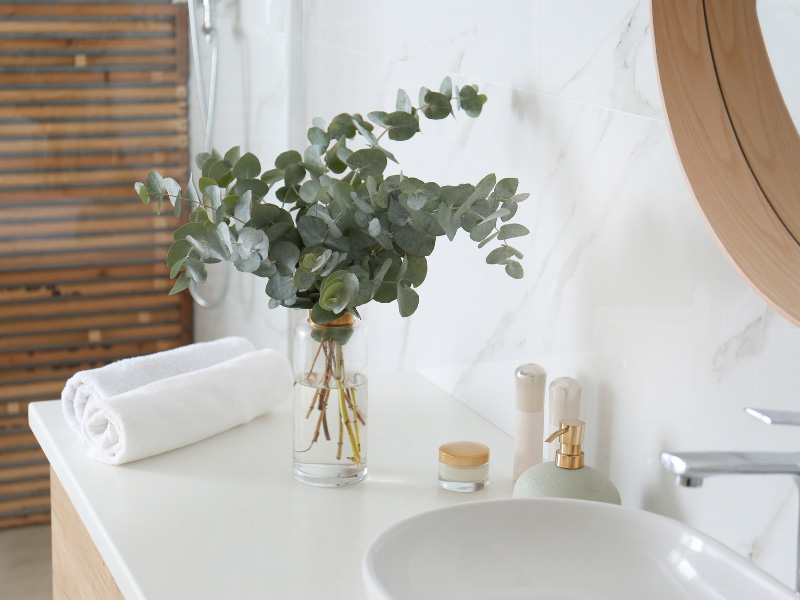 vas-of-eucalyptus-on-newly-renovated-batheroom-counter-top-beside-rolled-up-fresh-white-face-towels