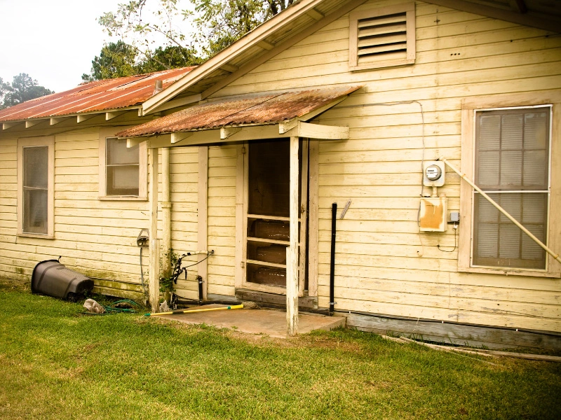 old-house-that-hasnt-had-siding-maintenance-in-years-showing-dirty-siding-and-mold-growth