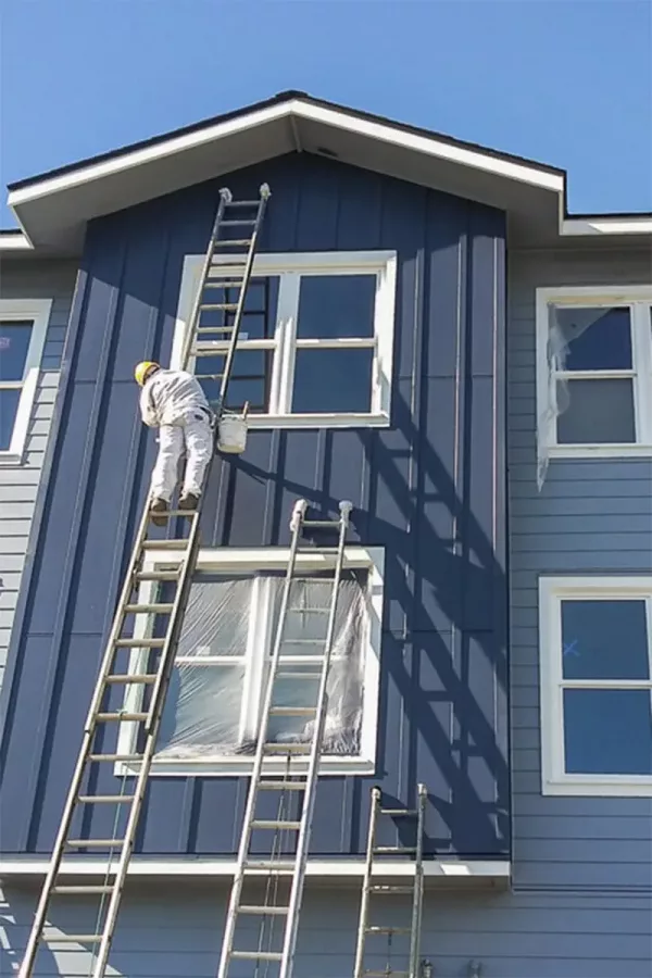 commercial painting services | sister siding man-on-ladder-working-on-house-siding
