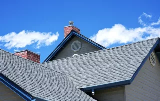 New gray shingle roof beneath a bright blue sky