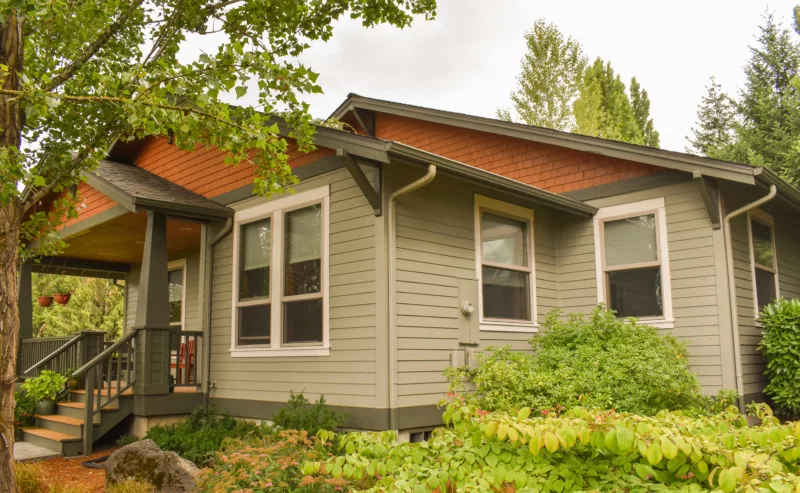 light washed green home with dark green trim and orange accent