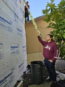lucas project manager on site 1 Man in a red polo inspecting exposed house wrap