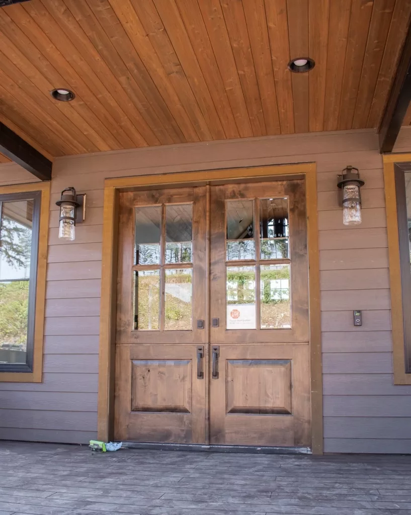 natural wood door with brown trim and brownish painted exterior