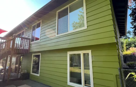 newly replaced siding and painted green on two story home