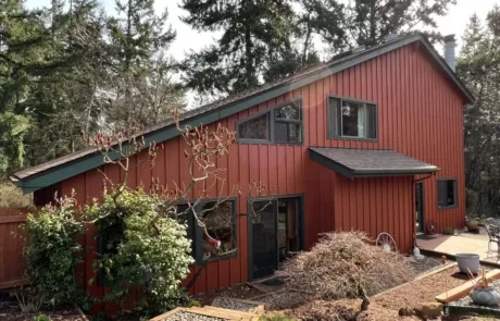 triangular home newly sided with red painted exterior finish