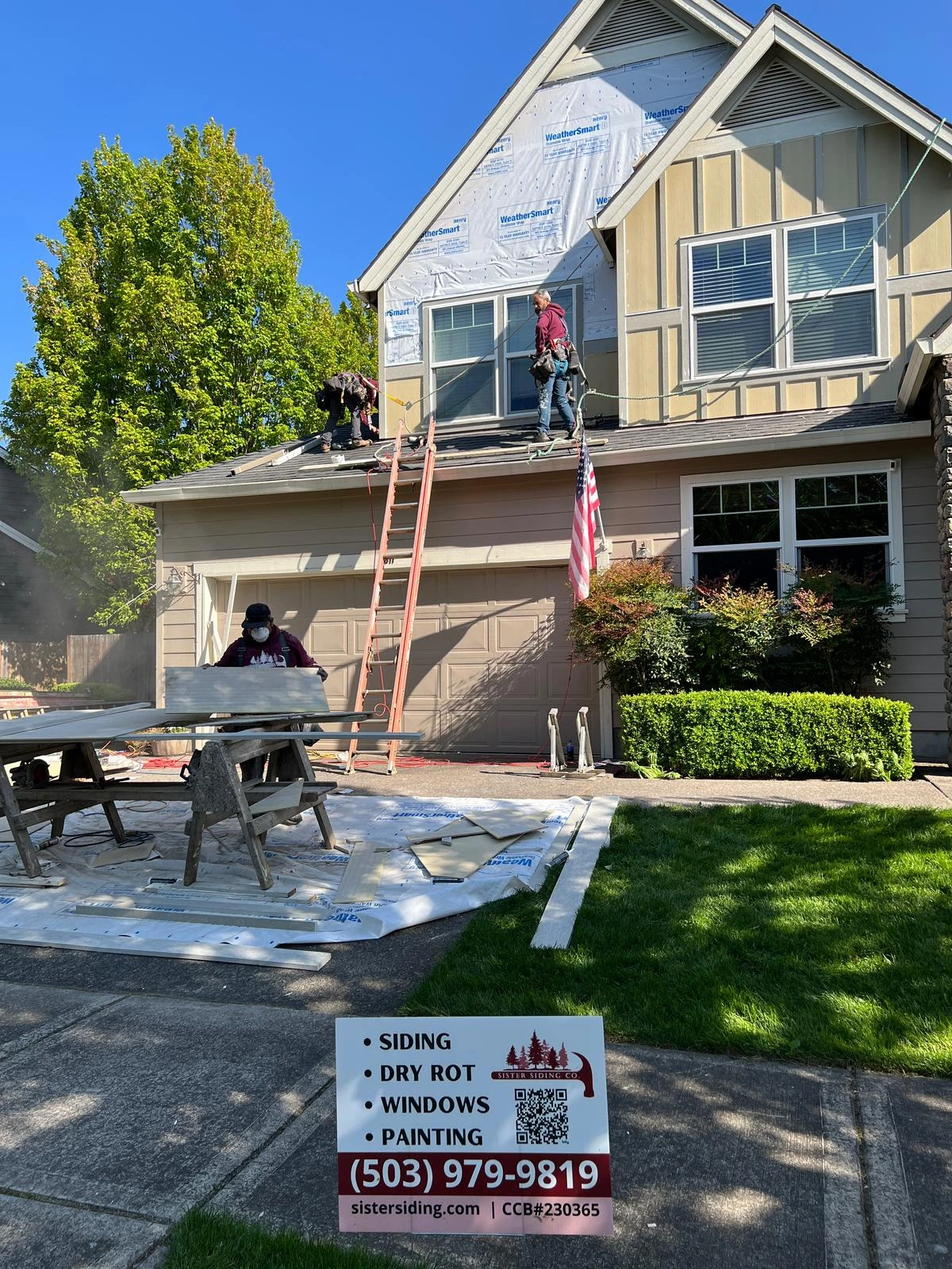 the sister siding crew repairing the siding of the second floor of a house