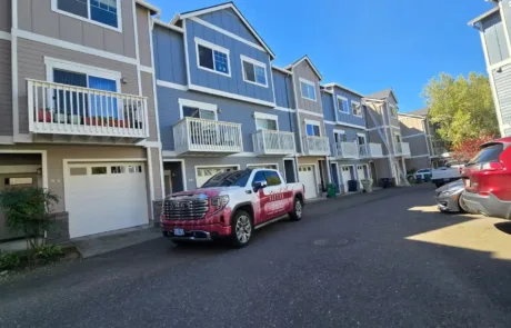 Stonewall HOA 1 after (1) (1) Row of blue-gray townhomes with white trim
